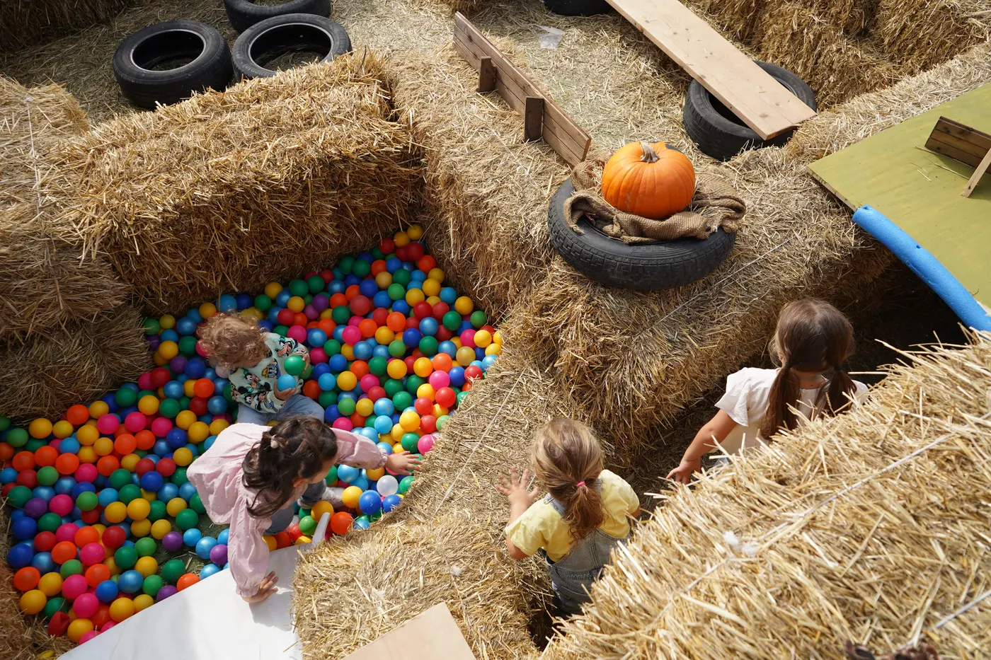 Bambini che giocano nella vasca di palline tra il fieno
